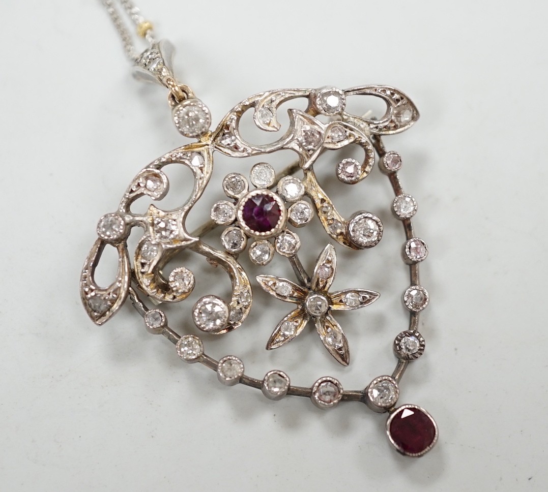 A yellow and white metal, ruby and diamond cluster set drop pendant brooch, 49mm, on an 18ct gold chain, 42cm, gross weight 11.5 grams.